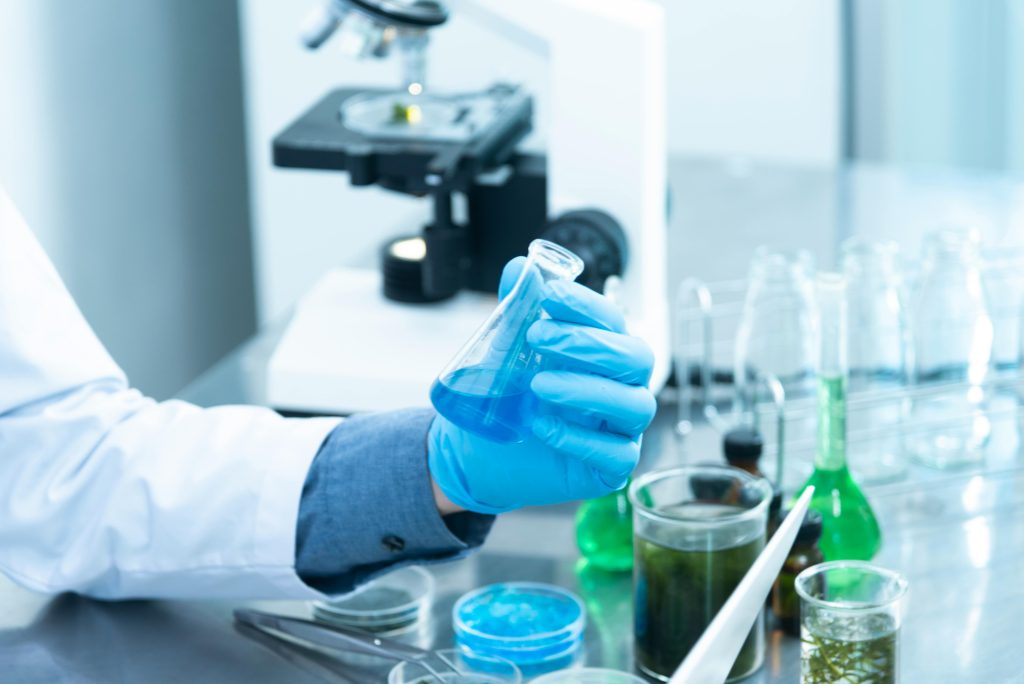 Lab technicians examining bacteria cultures under microscope